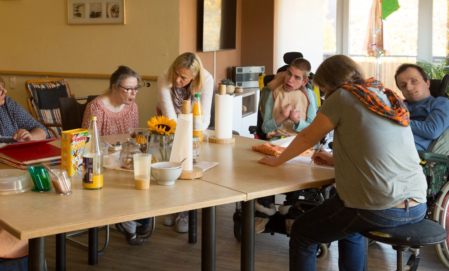 Bewohner sitzen zusammen am Tisch